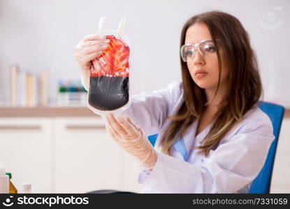 Female assistant with bag of blood in the lab 