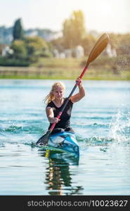 Female athelete training kayaking on lake