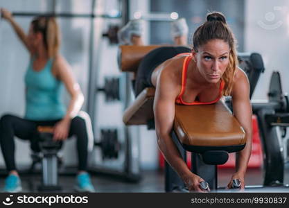 Female Athlete Exercising at Lying Leg Curl Bench in The Gym