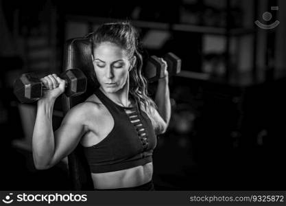 Female Athlete Exercising with Dumbbells in the Gym. Strength Training.. Exercising with Dumbbells in the Gym. Strength Training.