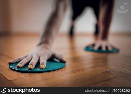 Female Athlete Exercising with Sliding Discs. Focus on Arms.. Female Athlete Exercising with Sliding Discs.