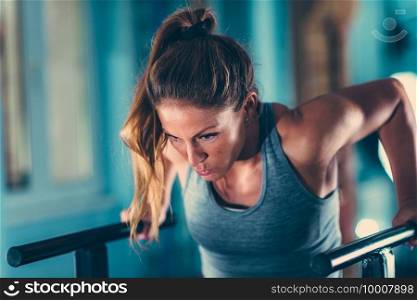 Female athlete in a gym, parallel bars exercising