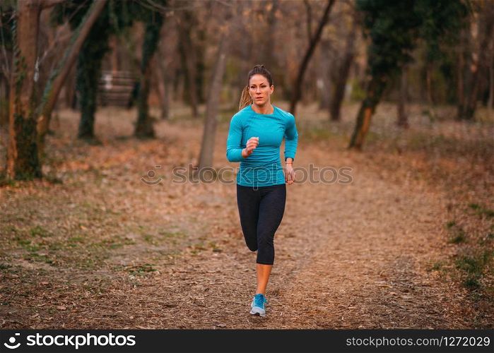Female Athlete Jogging in Park. Autumn, Nature. Female Athlete Jogging in the Park