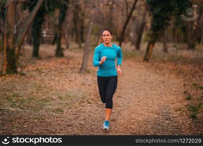 Female Athlete Jogging in Park. Autumn, Nature. Female Athlete Jogging in the Park
