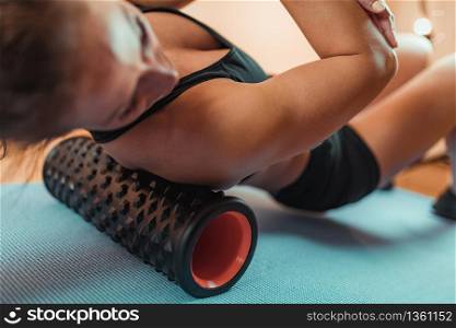 Female Athlete Massaging Shoulders with Foam Roller. Shoulder Massage with Foam Roller