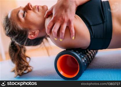Female Athlete Massaging Shoulders with Foam Roller. Shoulder Massage with Foam Roller