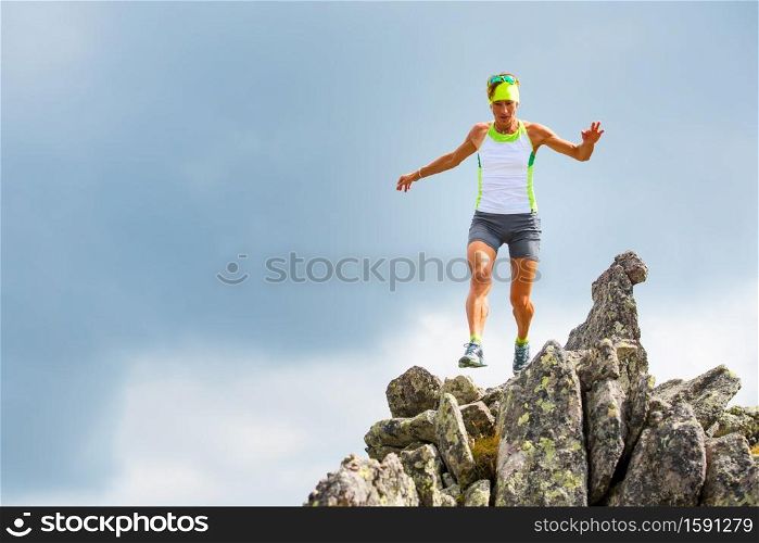 Female athlete of mountain running trains on the stones