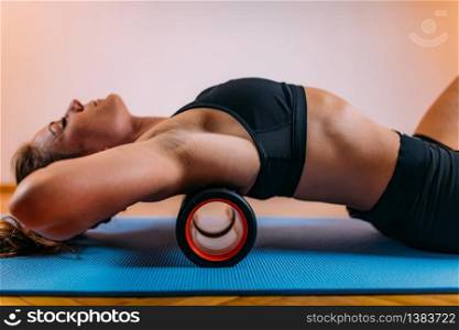 Female Athlete Stretching Back at Home with Foam Roller. Foam Roller Back Stretching at Home
