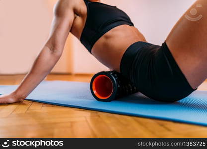 Female Athlete Stretching Lower Back Muscles with Foam Roller at Home. Foam Roller Lower Back Muscle Stretching at Home