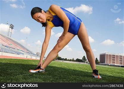 Female athlete stretching, portrait