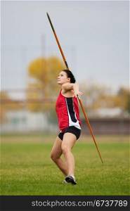 Female athlete throwing a javelin at a track and field sports event