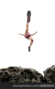 Female athlete trail in the mountains during a jump among the rocks
