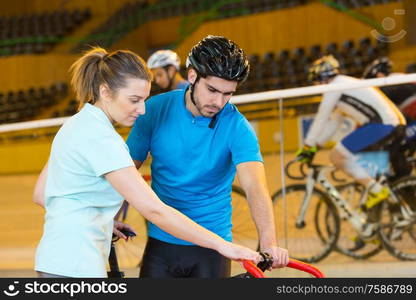 female athlete training in the velodrome with coach