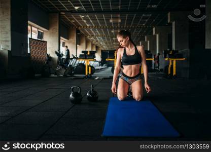 Female athlete trains press in sport gym, top view. Young woman in fitness club, fit training. Female athlete trains press in sport gym, top view