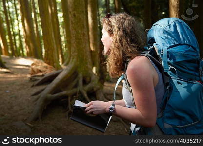 Female backpacker hiking in woods