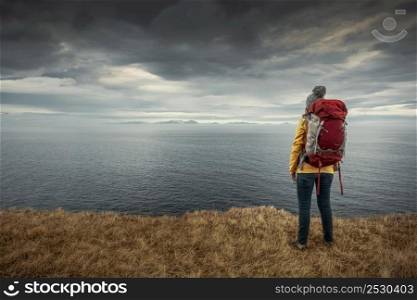 Female backpacker traveller in Iceland watching the Ocean