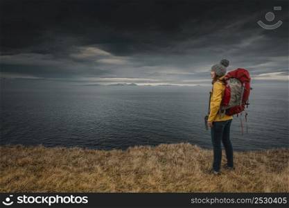 Female backpacker traveller in Iceland watching the Ocean