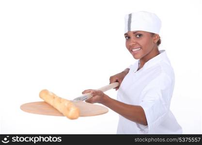 Female baker baking a baguette