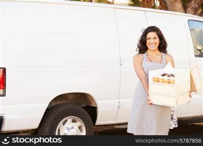 Female Baker Delivering Cakes Standing In Front Of Van