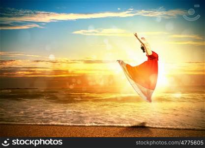 Female ballet dancer. Image of female ballet dancer against sunset background soaring above water waves