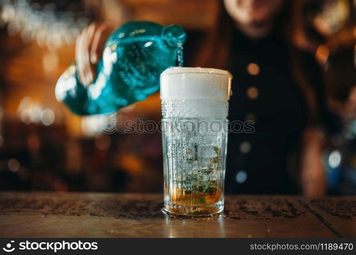 Female barman pours aerated water into a glass. Woman bartender mixing at the bar counter in pub. Barkeeper occupation. Female barman pours aerated water into a glass