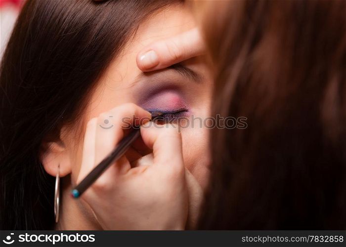 Female beauty. Makeup artist stylist applying with brush eyeshadow on eyelid of young woman. Girl by visagiste.