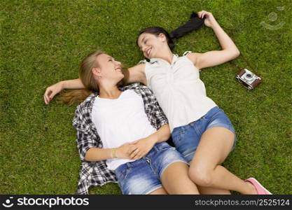 Female best Friends lying on the grass and having a good time together