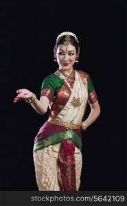 Female Bharata Natyam performer over black background