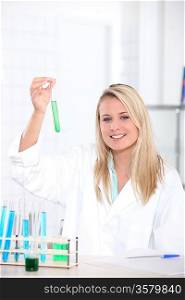 female biologist in laboratory holding test tube