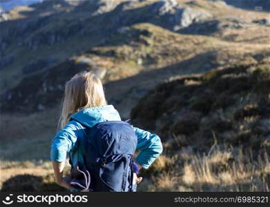 Female blond backpacker with mountain background