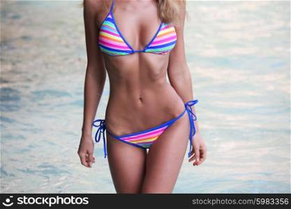 Female body in bikini. Woman with perfect body in bikini on sea background