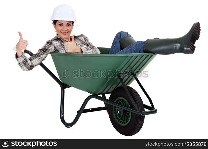 female bricklayer thumbs up in wheelbarrow