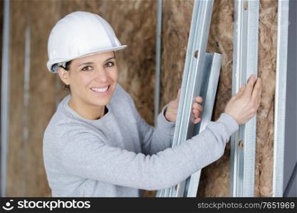 female builder holding metal bars