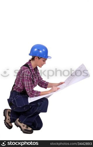 Female builder looking at architect plans