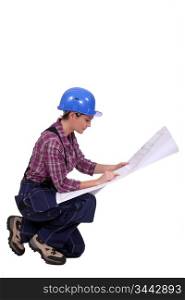 Female builder looking at architect plans
