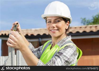 female builder measuring concrete block