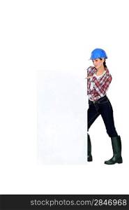 Female builder pointing at poster