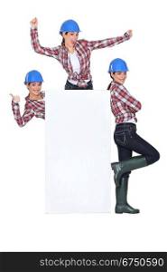 Female builder posing round a board left blank for your message