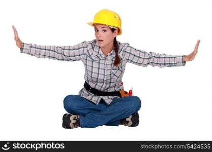 Female builder sitting with arms stretched