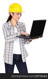 Female builder stood with laptop
