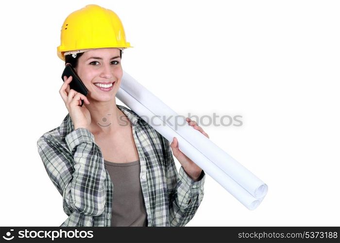 Female builder with plans and mobile telephone