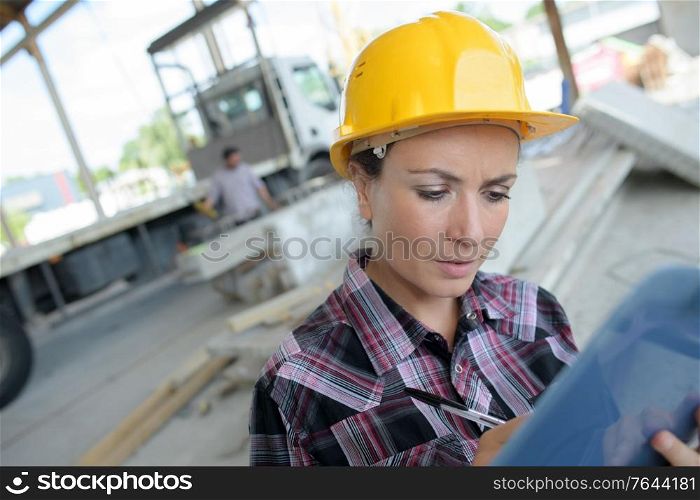 female builder writes results of inspection outdoors