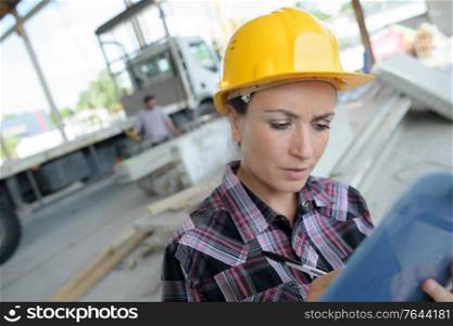 female builder writes results of inspection outdoors
