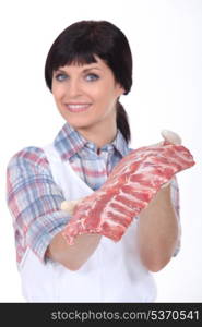 Female butcher stood with raw meat