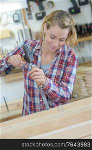 female cabinet maker making tiny details on the wood