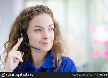 female call-center agent with headset working on support hotline in the office