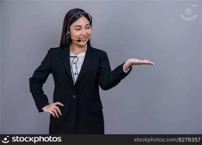 Female call center operator wearing headset and formal suit standing confidently with holding hand gesture for product advertisement or HR recruitment on isolated background. Jubilant. Female call center operator wearing headset making hand gesture. Jubilant