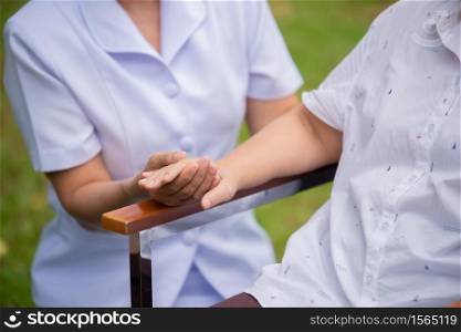 Female Caretaker With Senior Woman In Yard