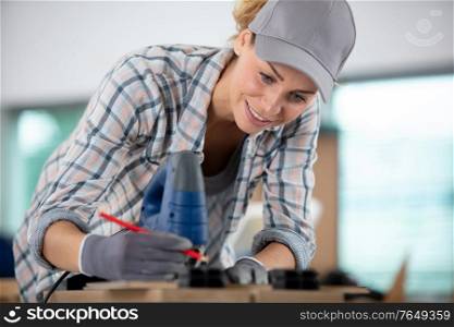 female carpenter marking wood in workshop