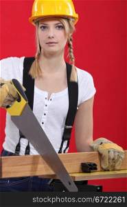 Female carpenter sawing.